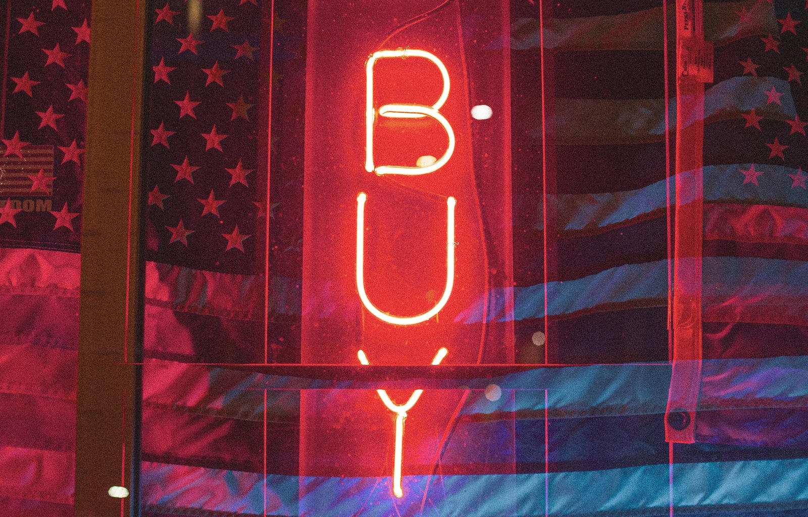 neon "buy" sign in front of american flag